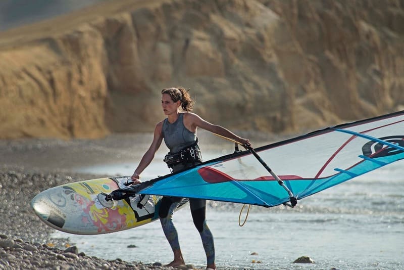 Windsurfing champion carolina buteich holding her windsurfing board