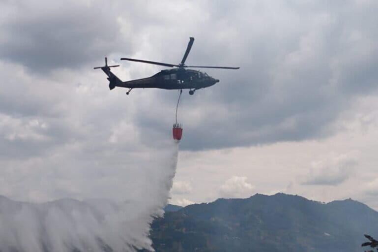 Helicopter dropping water on fires in Colombia