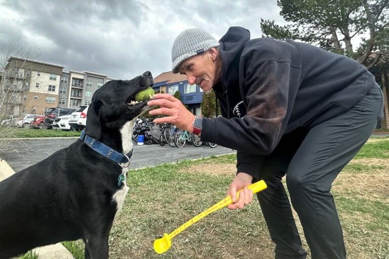 Homeless shelters for seniors. Man plays with his dog outside