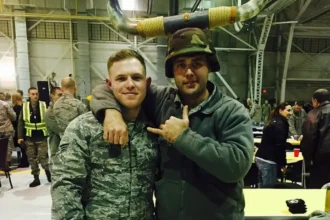 Taylor rehmet in his military uniform posing with another service member.