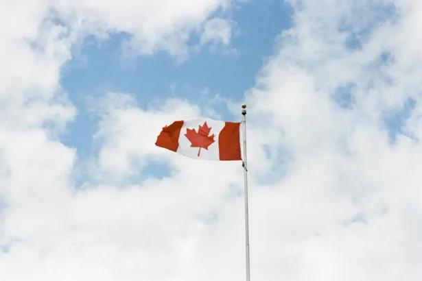 Canadian flag against a cloudy blue sky