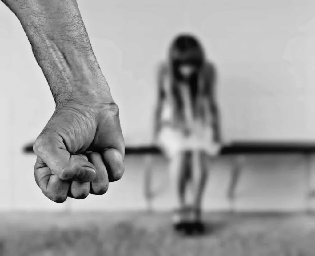 Black and white photo of a man’s fist and a woman in a blurred background