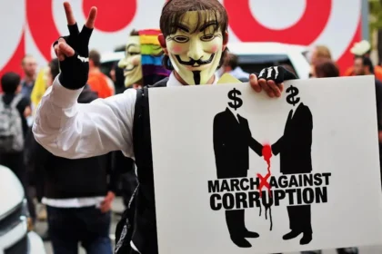Money in politics A protester wears a Guy Fawkes mask holding a sign at a rally against corruption in Washington, DC.
