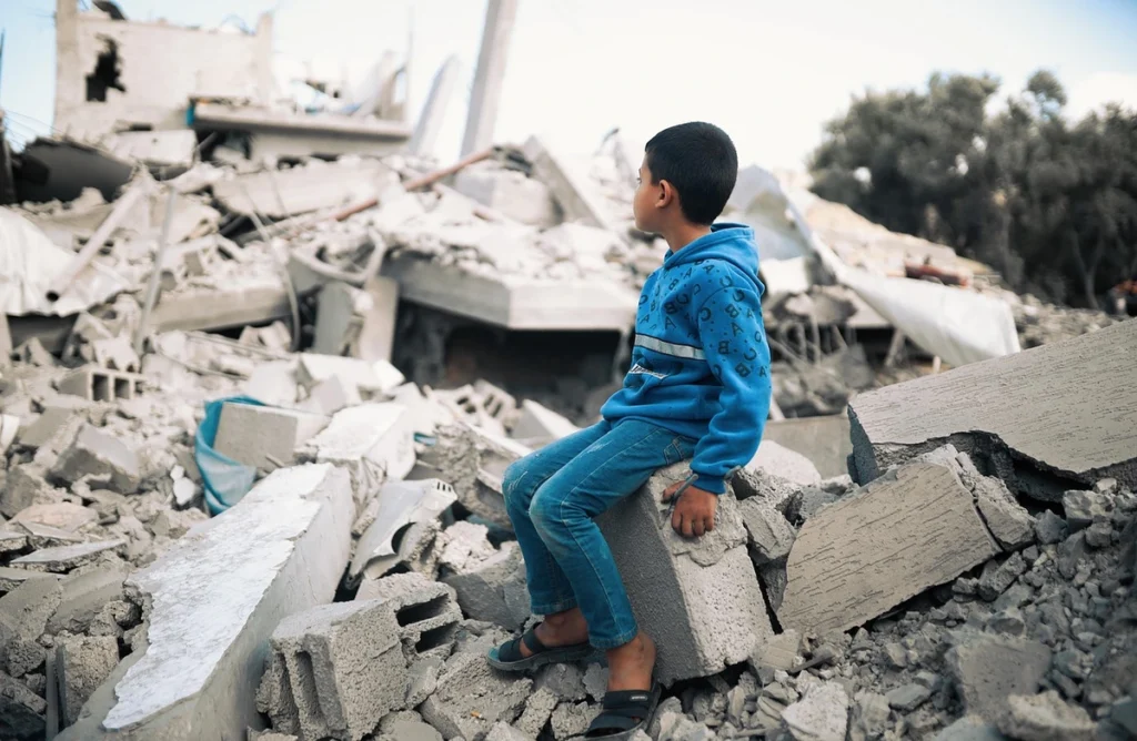 Boy sitting on rubble in gaza