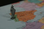 Ancient metal soldier on a map of the world