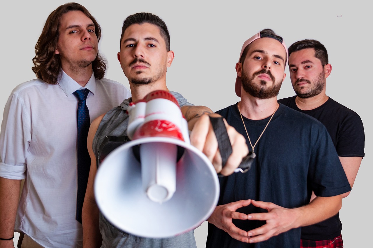 4 men in a group with one holding a bullhorn