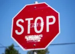 Stop sign with trump added underneath the word stop