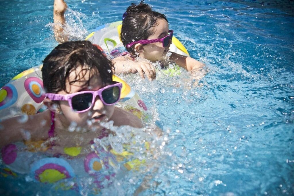girls swimming Girls on rafts in a swimming pool wearing sunglasses