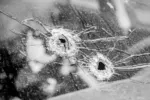 Police shot 1-year-old in car at walmart. Photo of car window with two bullet holes in it